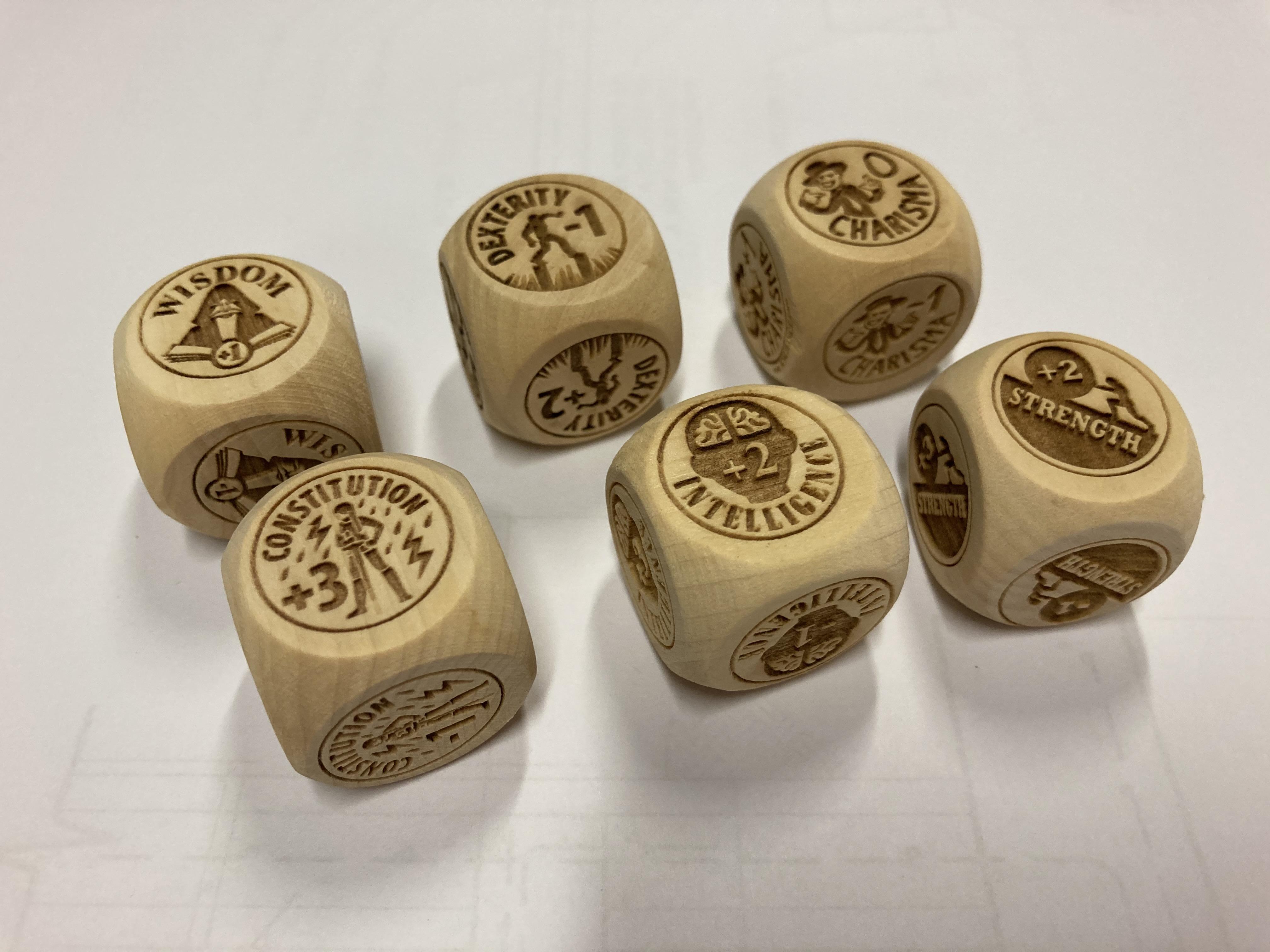 Six attribute dice are stacked in a pyramid
                        formation atop a blue table.  In front of the dice
                        pyramid lays a quarter.  The quarter has about the same
                        area as a single side of a die.